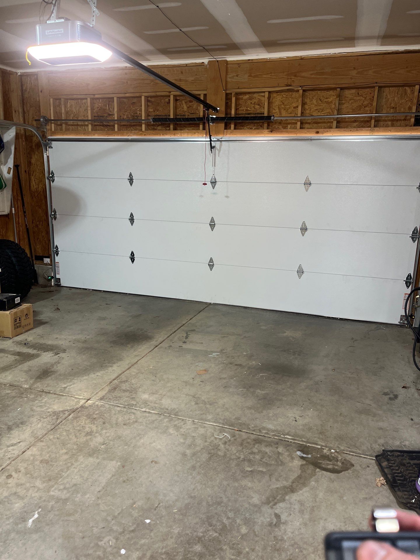 Garage door technician inspecting rollers, hinges, and tracks. garage door parts