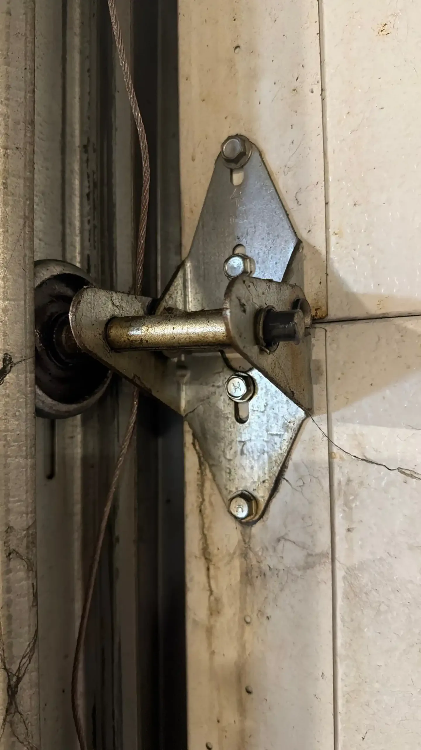 Garage door technician inspecting rollers and tracks on a residential garage door